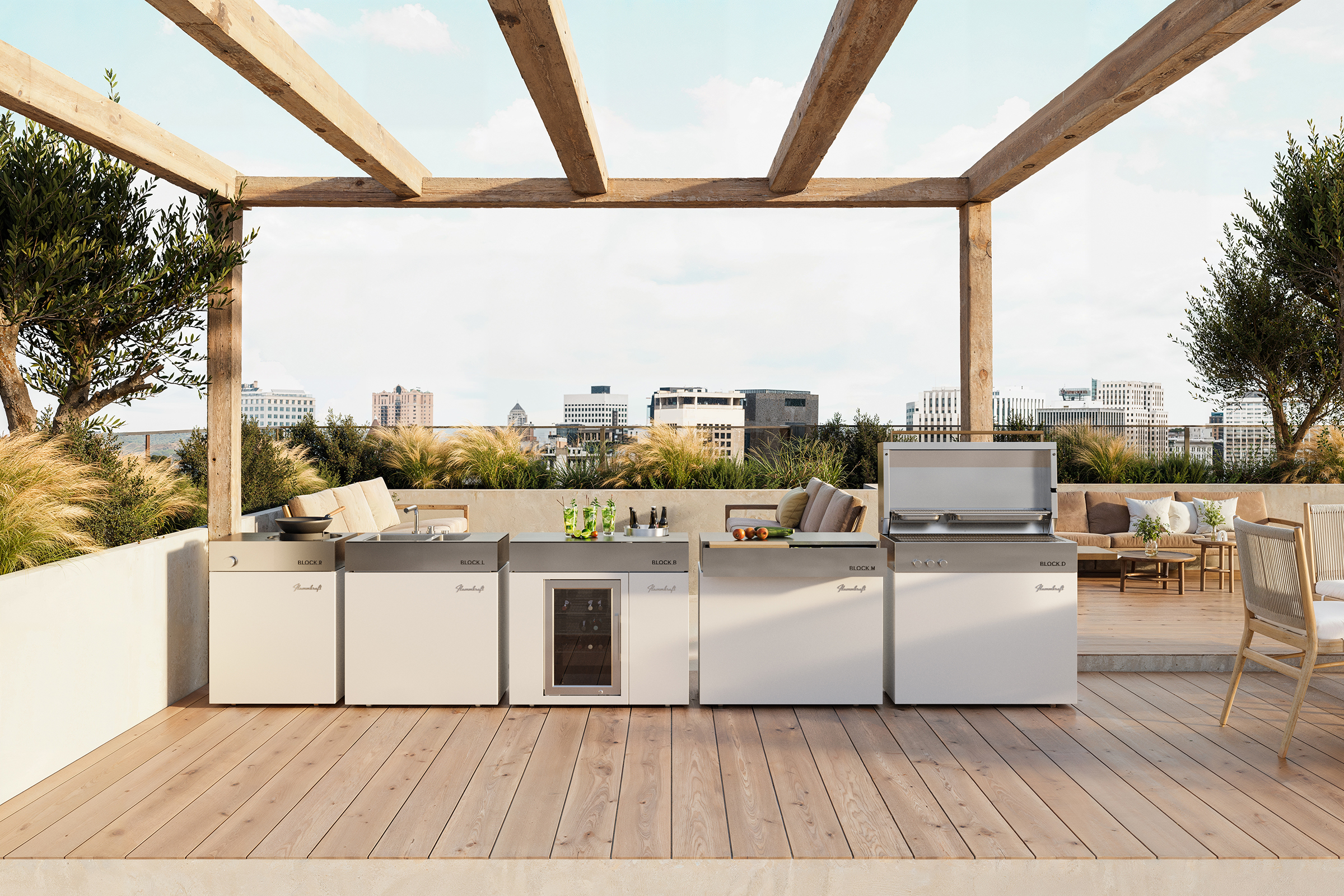 Luxuriöse Dachterrasse mit einer voll ausgestatteten Flammkraft Outdoorküche unter einer rustikalen Holz-Pergola. Die hellen Module (Block D, B, L, R und M) bieten Grillen, Kochen und Kühlen vor einer urbanen Skyline.